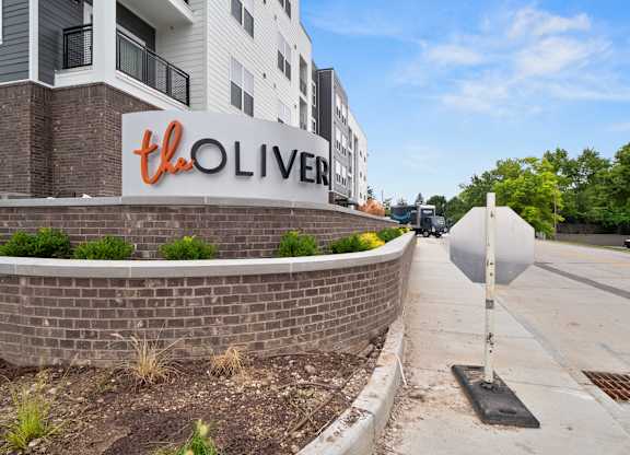 The Oliver apartment complex is located on a quiet street with a sidewalk and landscaping at The Oliver Apartments, Olivette, 63132