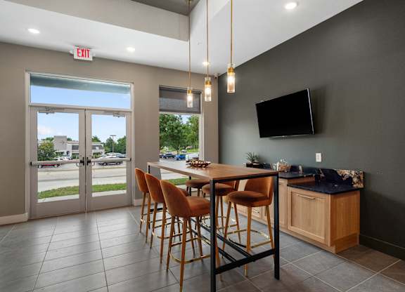 A modern dining room with a wooden table and chairs at The Oliver Apartments, Olivette
