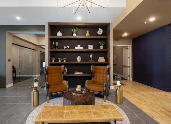 A modern living room with a fireplace and two chairs. at The Oliver Apartments, Olivette, MO
