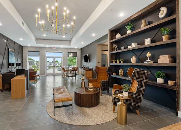 A modern living room with a large window and a variety of seating options at The Oliver Apartments, Missouri, 63132