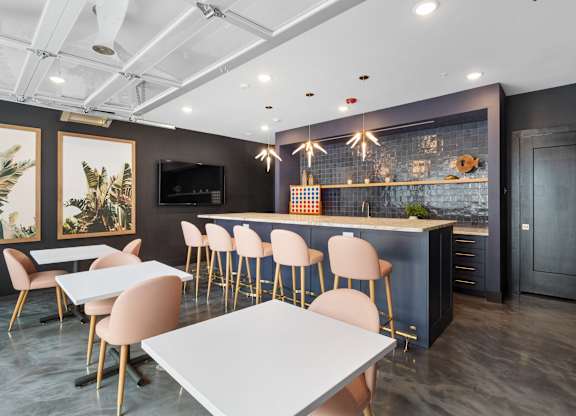 A modern dining area with a bar and chairs at The Oliver Apartments, Olivette