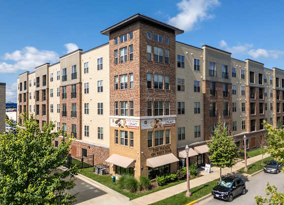 A large apartment complex with a parking lot in front.