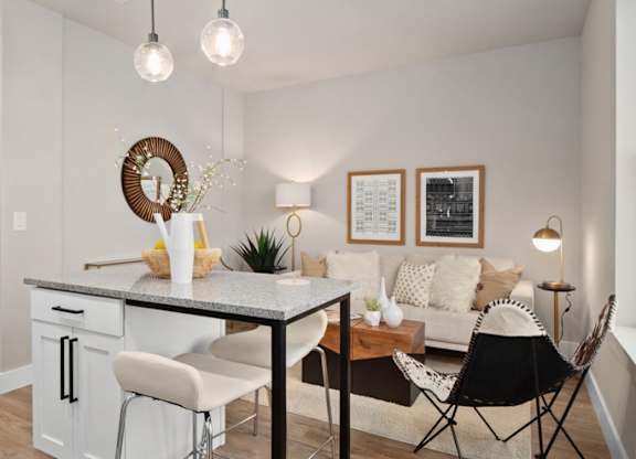 A modern kitchen with a dining table and chairs at The Oliver Apartments, Olivette, MO