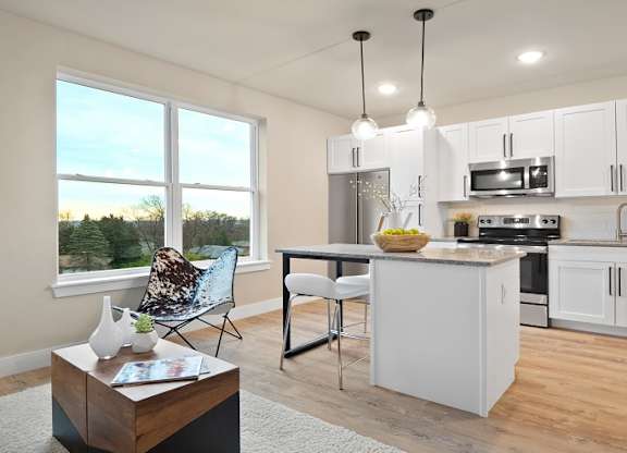 A modern kitchen with white cabinets and stainless steel appliances at The Oliver Apartments, Olivette, MO