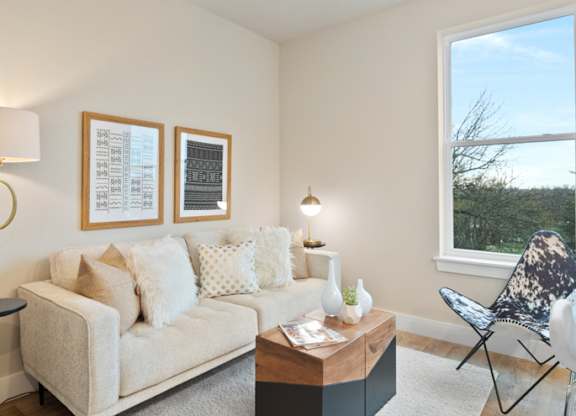 A living room with a couch, a coffee table, and a chair at The Oliver Apartments, Olivette, Missouri