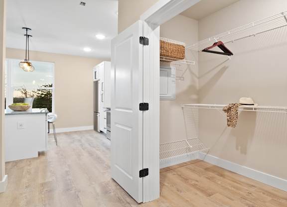 A kitchen with a white fridge and a white door is shown at The Oliver Apartments, Olivette, MO, 63132