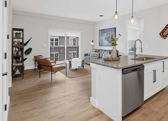 A modern kitchen with a wooden floor and white walls at The Oliver Apartments, Olivette, MO, 63132