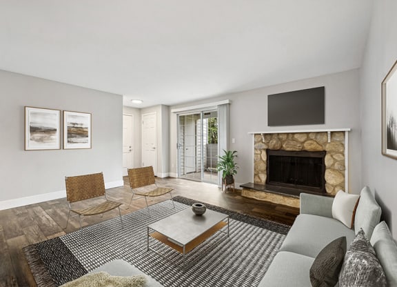 Model Living Room with Wood-Style Flooring, a Fireplace and Patio Accessibility at Central Flats Apartments in Kent, WA.