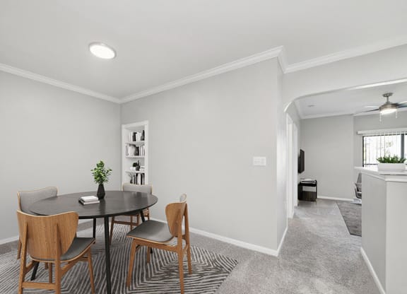 Model Dining Room with Carpet and View of Living Room at Hidden Creek Apartments located in Lewisville, TX.