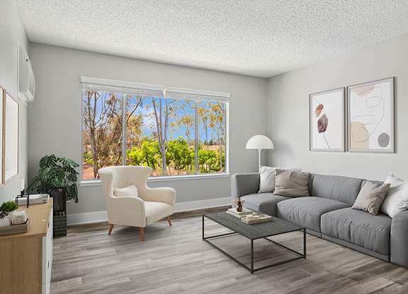 Model Living Room with Wood-Style Flooring and Window View at Fullerton Hills Apartments located in Fullerton, CA.