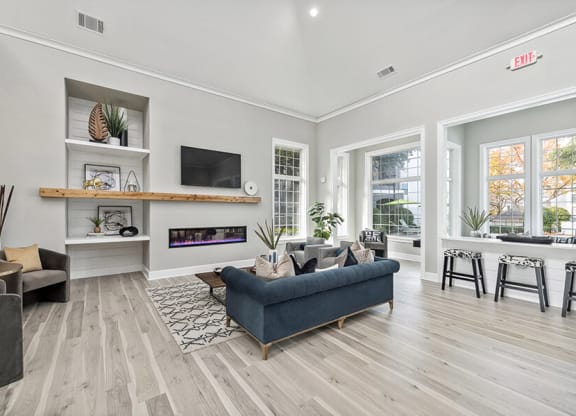 Community Clubhouse with Lounge Furniture and Fireplace at Bridges at Oakbend Apartments in Lewisville, TX.