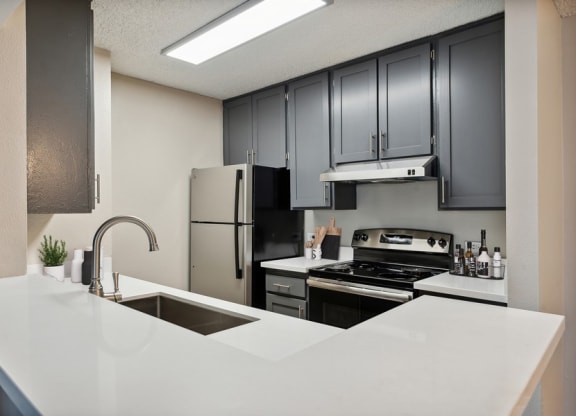 Model kitchen with dark cabinets and light countertops