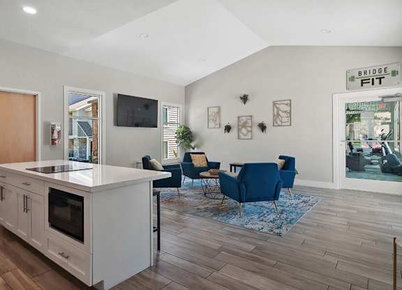 Community Clubhouse with Lounge Furniture and Kitchenette Area at Broadmoor Village Apartments located in West Jordan, UT.