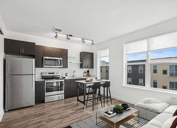 Model Kitchen with Dark Wood Cabinets and Wood-Style Flooring at Stella Apartments located in New Carrollton, MD.