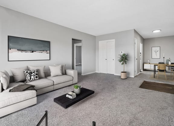 Model Living Room with Carpet and View of Dining Room at Stone Ends Apartments in Stoughton, MA.