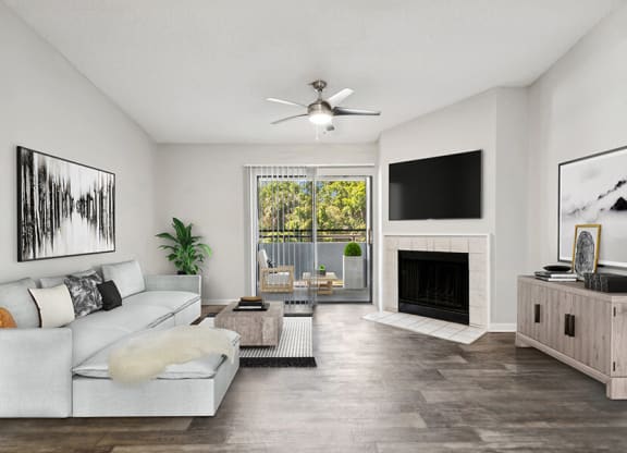 Model Living Room with Wood-Style Flooring, Fireplace & Patio Accessibility at Rosehill Preserve Apartments located in Orlando, FL.