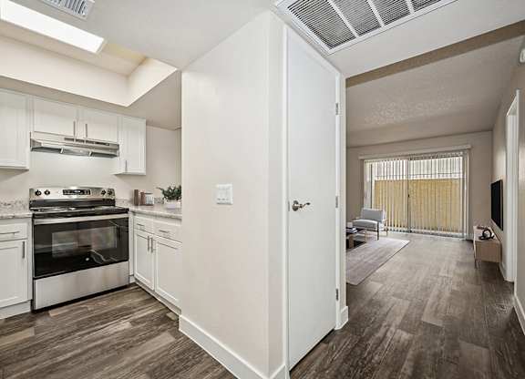 Model Kitchen with White Cabinets and Wood-Style Flooring at Butler Ridge Apartments located in Glendale, AZ.