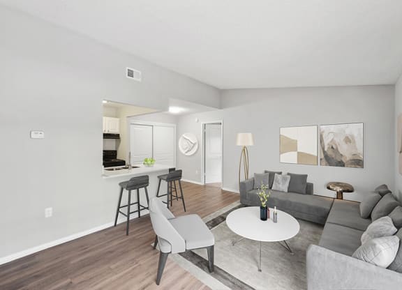Model Living Room with Wood-Style Flooring and View of Kitchen at Vue at Baymeadows Apartments in Jacksonville, FL.