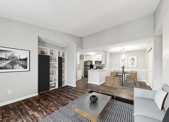 Model Living Room with Wood-Style Flooring and View of Kitchen/Dining Area at Commons at Haynes Farm Apartments in Shrewsbury, MA.