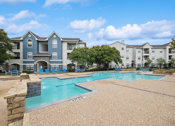 Community Swimming Pool with Pool Furniture at Hidden Creek Apartments located in Lewisville, TX.