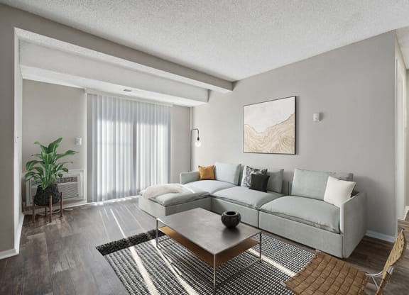 Model Living Room with Wood-Style Flooring and Patio Accessibility at Liberty Creek Apartments in Aurora, CO.
