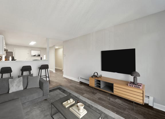 Model Living Room with Wood-Style Flooring and View of Kitchen at Middlesex Crossing Apartments in Billerica, MA.