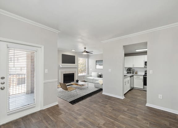 Model Living Room with Wood-Style Flooring and Fireplace at Chapel Hill Apartments in Lewisville, TX.