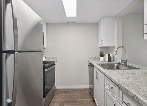 Model Kitchen with White Cabinets and Wood-Style Flooring at Overlook Point Apartments in Salt Lake City, UT.