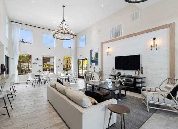 Community Clubhouse with Lounge Furniture and a TV at Rosehill Preserve Apartments in Orlando, FL.
