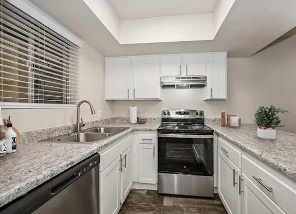 Model Kitchen with White Cabinets and Wood-Style Flooring at Butler Ridge Apartments located in Glendale, AZ.