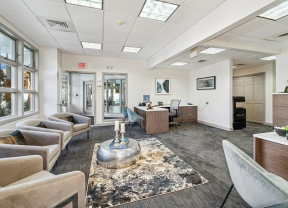 Leasing office interior with couches and chairs and a coffee table in the middle of the room