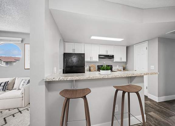 Model Kitchen with White Cabinets and Wood-Style Flooring at Stillwater Apartments located in Glendale, AZ.