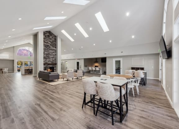 a large living room with a table and chairs and a fireplace