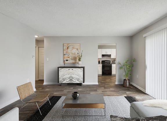 Model Living Room with Wood-Style Flooring and View of Kitchen at Parc at Creekside Apartments in Kansas City, MO.