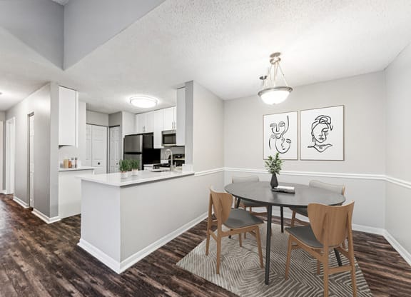 Model Dining Room with Wood-Style Flooring and View of Kitchen at Commons at Haynes Farm Apartments in Shrewsbury, MA.