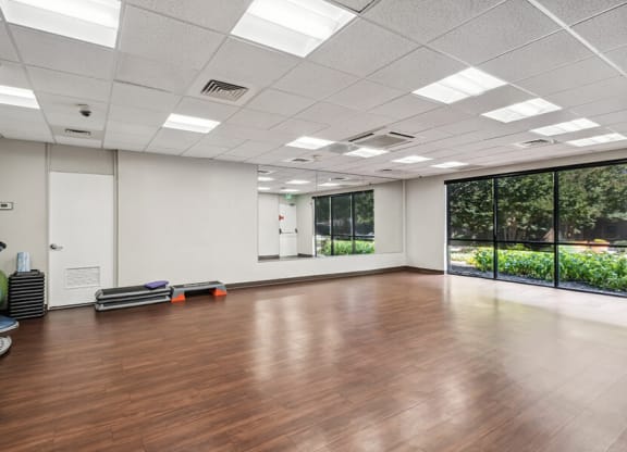 Community Exercise Room with Mirrors and Fitness Equipment at Mason Van Dorn Apartments located in Alexandria, VA.