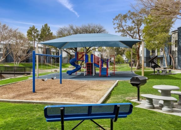 a playground with a slide and picnic table