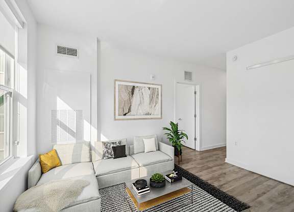 Model Living Room with Wood-Style Flooring and Window View at Stella Apartments located in New Carrollton, MD.