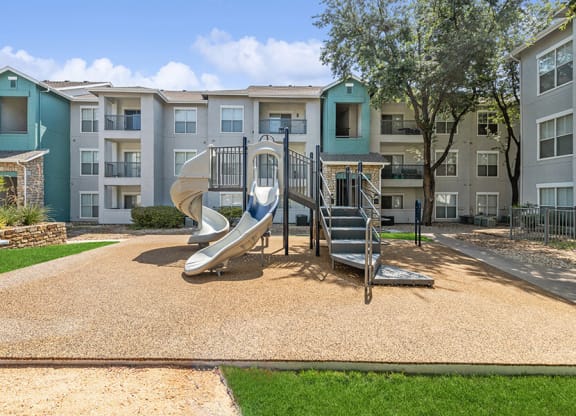 Community Playground with a Slide at Essence Apartments in Dallas, TX.