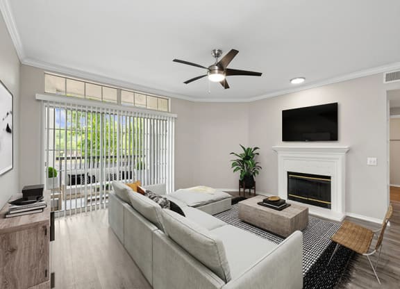 Model Living Room with Wood-Style Flooring, Fireplace & Patio Accessibility at Allure North Dallas Apartments located in Dallas, TX.