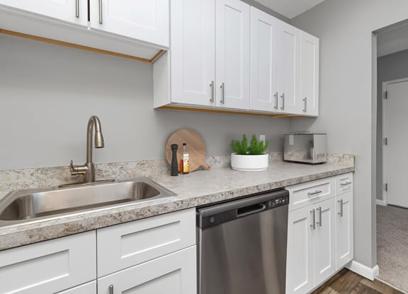 Model Kitchen with White Cabinets and Wood-Style Flooring at Stone Ends Apartments in Stoughton, MA.
