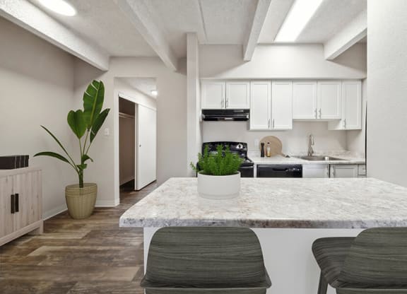 Model Kitchen with White Cabinets and Wood-Style Flooring at Esprit at Cherry Creek Apartments in Glendale, CO.