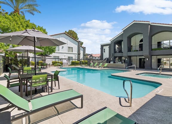 Community Swimming Pool with Pool Furniture at Meadow Ridge Apartments located in Las Vegas, NV.