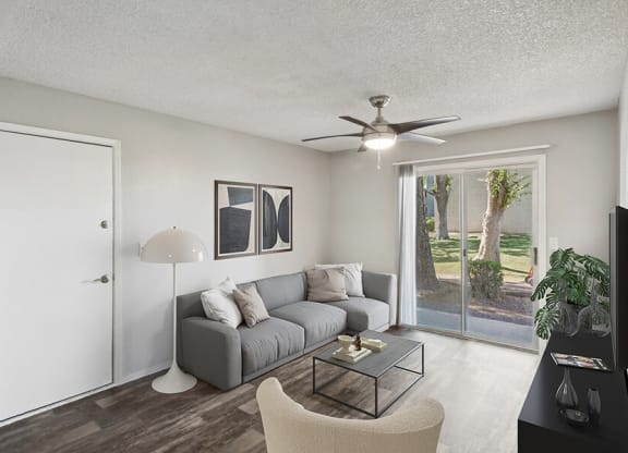 Model Living Room with Wood-Style Flooring and Patio Accessibility at Solano Springs Apartments located in Tucson, AZ.