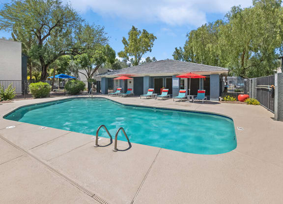 Community Swimming Pool with Pool Furniture at Solano Springs Apartments in Tucson, AZ.