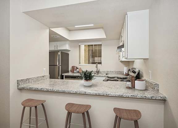 Model Kitchen with White Cabinets and Wood-Style Flooring at Butler Ridge Apartments located in Glendale, AZ.