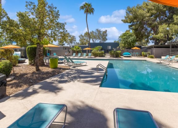 Community Swimming Pool with Pool Furniture at Lakeside Casitas Apartments in Tucson, AZ.