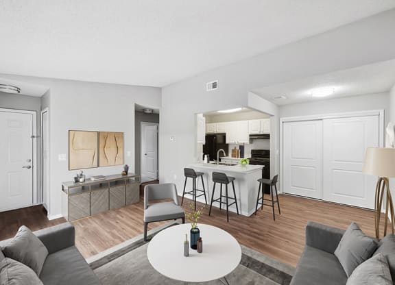 Model Living Room with Wood-Style Flooring and View of Kitchen at Vue at Baymeadows Apartments in Jacksonville, FL.