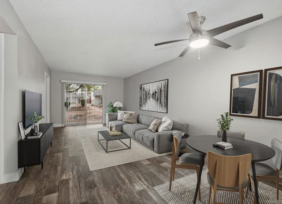 Model Living Room with Wood-Style Flooring and Patio Accessibility at Crystal Creek Apartments located in Phoenix, AZ.