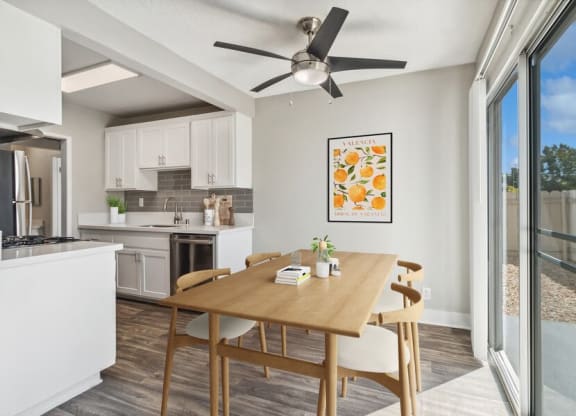 Model Dining Room with Wood-Style Flooring & View of Kitchen at Forest Park Apartments in El Cajon, CA.